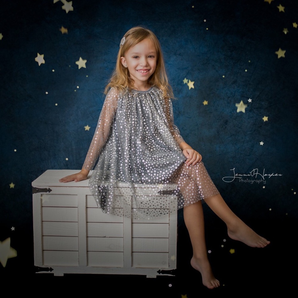 Gray dress with silver stars on a sheer layer.